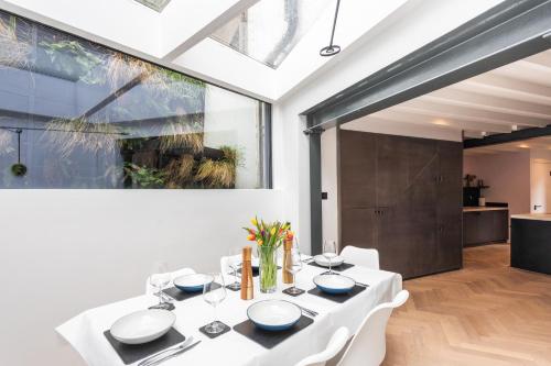 una sala da pranzo con tavolo e sedie bianchi di Stunning Townhouse with large roof terrace a Londra