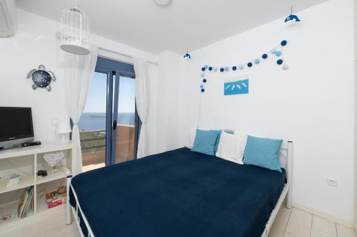 a bedroom with a bed and a window with the ocean at Wonderful maisonette overlooking the Aegean Sea in Petriaí