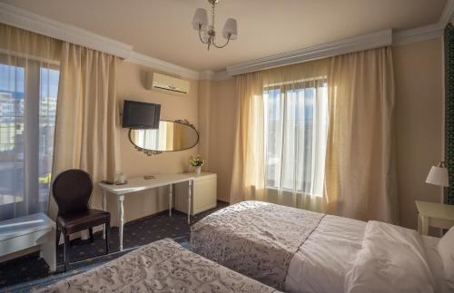 Habitación de hotel con cama, escritorio y espejo. en Hotel Eden en Iaşi