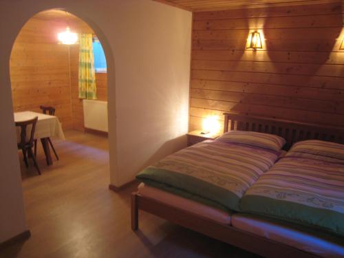 ツェル・アム・ゼーにあるSki-in Ski-out Chalet Kriekels - by Alpen Apartmentsの木製の壁のベッドルーム1室(ベッド1台付)