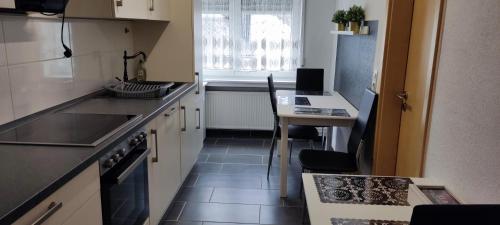 a small kitchen with a sink and a table at APPARTEMENT GEICHLINGEN in Geichlingen