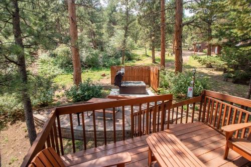 a wooden deck with two benches and a fire pit at Castle Mountain Lodge in Estes Park