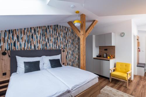 a bedroom with a white bed and a yellow chair at Hotel Restovna in Jíloviště