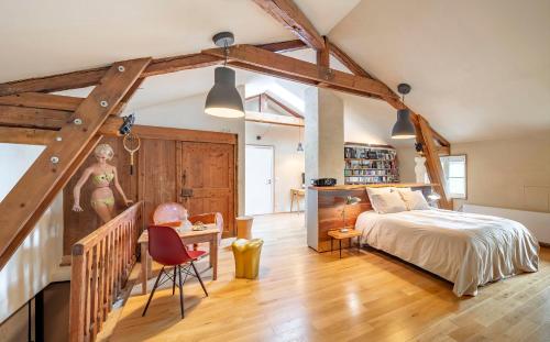 1 dormitorio con 1 cama y 1 mesa con silla en Ancienne fabrique de soie À la Galicière, en Chatte