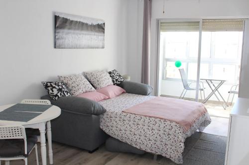a living room with a couch and a bed at Charming Studio Nerja with pool in Nerja