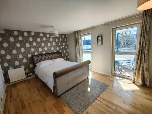 a bedroom with a bed and a large window at Holywood Sea Renity in Holywood