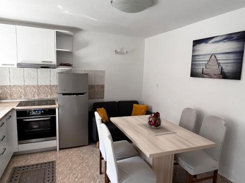 uma cozinha e sala de jantar com mesa e cadeiras em Apartman Kalinić em Ston