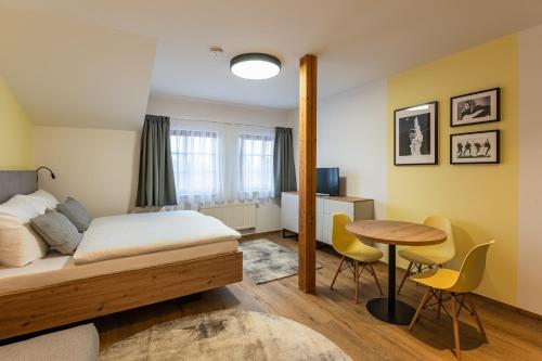 a bedroom with a bed and a table and chairs at Hotel Restovna in Jíloviště