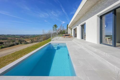 a swimming pool on the side of a house at VILLA LE BELVEDERE-DESIGN-PISCINE-VUE-GAILLAC in Salvagnac