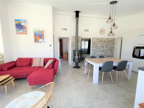 salon z czerwoną kanapą i stołem w obiekcie Casa Vecchia w mieście Sainte-Lucie de Porto-Vecchio