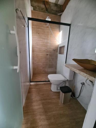 a bathroom with a toilet and a shower with a mirror at Casa Angra vista pro mar in Angra dos Reis