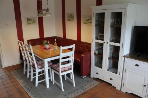 a dining room with a table and a couch at Huus Diekkieker in Nordstrand