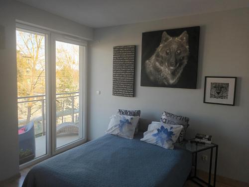 sypialnia z łóżkiem i zdjęciem wilka w obiekcie Kapitańska Apartament w mieście Gdynia