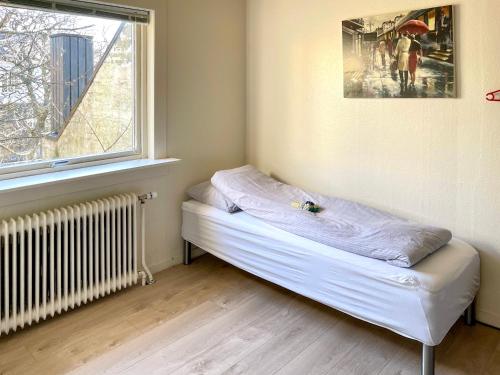uma pequena cama num quarto com uma janela em Liv's Guesthouse em Tórshavn