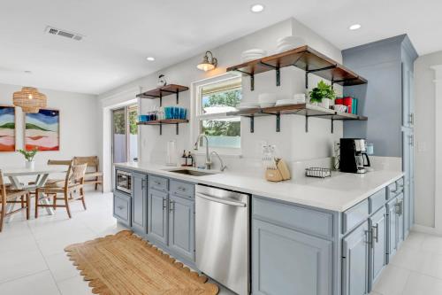 a kitchen with blue cabinets and a dining room at Pool Home Near Downtown, 5th Ave, Beaches & Pier in Naples