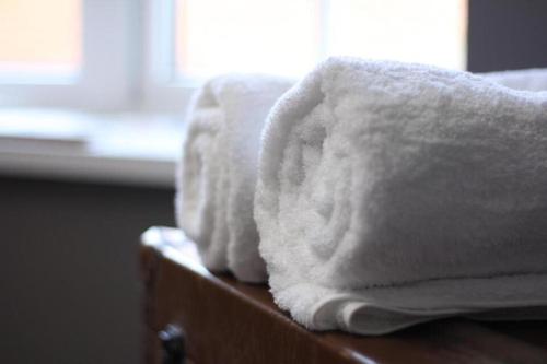 a pile of towels sitting on top of a dresser at The Old Talbot Hotel Milton Keynes in Potterspury