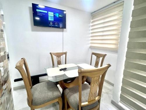 comedor con mesa, sillas y TV en Apartamento en Cartagena Cerca a la Playa, en Cartagena de Indias