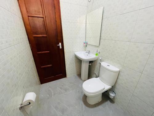 łazienka z toaletą i umywalką w obiekcie Revara Home w Dodomie