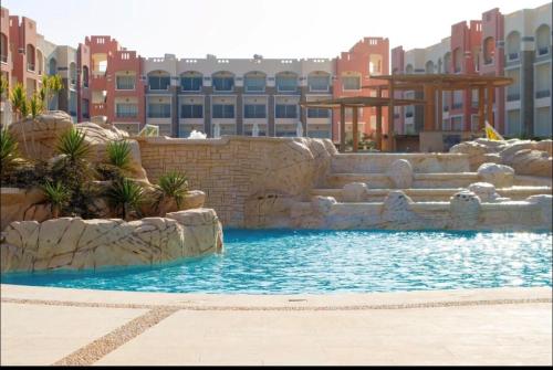 a swimming pool in the middle of a resort at Oyster Bay Resort, One Bedroom Beach Front Apartment, Marsa Alam in Abu Dabbab