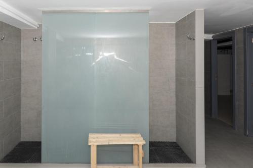 a glass wall in a room with a wooden table at Ferrobus Duplex in Cullera