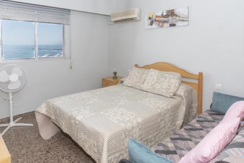 a bedroom with a bed and a window at Ferrobus Duplex in Cullera
