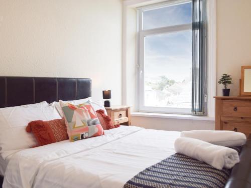 a bedroom with a white bed with a window at Marina Reach in Neyland