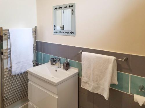 W łazience znajduje się umywalka, lustro i ręczniki. w obiekcie Marina Reach w mieście Neyland