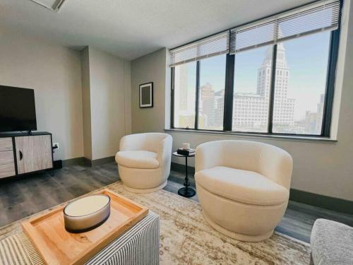 a living room with two chairs and a flat screen tv at Downtown Hartford Condo - XL Center in Hartford