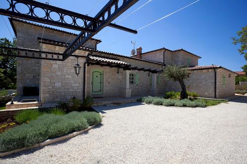 a brick house with a green door in a yard at Vila Romana in Barat