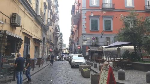 un gruppo di persone che camminano per una strada con edifici di Casa di Susy a Napoli