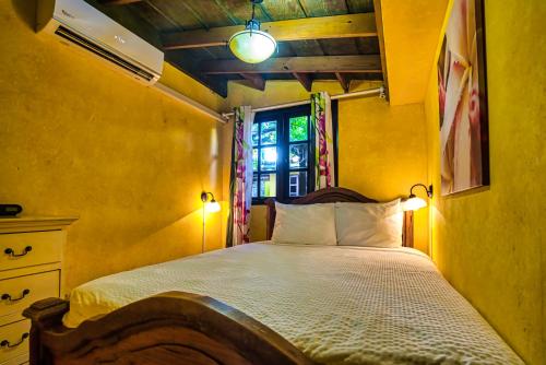 a bedroom with a bed with two lamps and a window at Villa Aloe in Paradijs