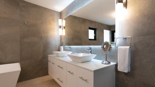 a bathroom with two sinks and a mirror at Bird of Paradise Villa in Palm-Eagle Beach