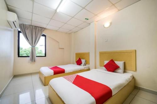 a bedroom with two beds and a window at Hotel River Inn in Butterworth