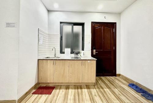 a bathroom with a sink and a brown door at The Jade Hotel near Tan Son Nhat Airport in Ho Chi Minh City