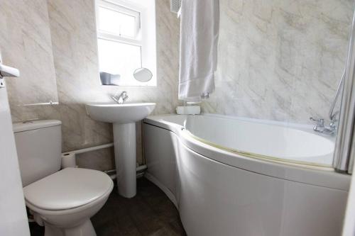 a bathroom with a toilet and a sink and a bath tub at Cul-de-sac Creations in Shrewsbury