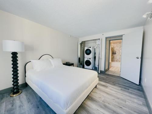 a white bedroom with a large bed and a hallway at The Hartford Skyline Downtown Hartford XL Center in Hartford