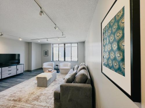 a living room with a couch and a flat screen tv at Downtown Hartford Condo - XL Center in Hartford