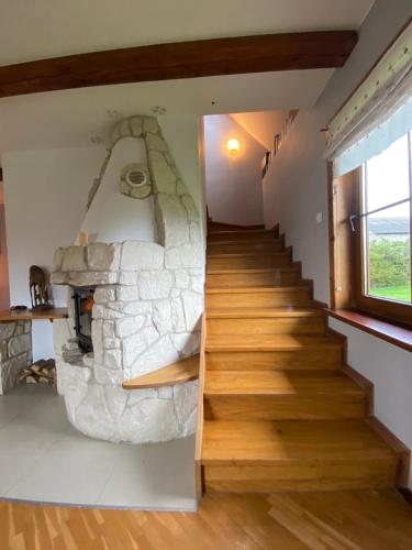 a staircase in a house with a stone fireplace at Chata Sikorki in Gorajec