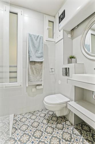 une salle de bain blanche avec des toilettes et un lavabo dans l'établissement Cozy 2-bedroom near Montmartre, à Paris