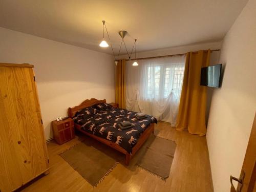 a bedroom with a bed and a large window at Apartament Zarnesti in Zărneşti