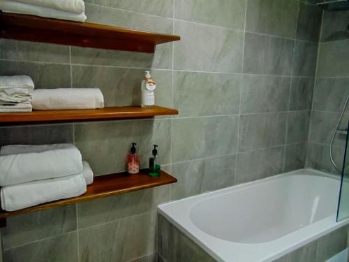 y baño con ducha, bañera y toallas. en O Kouche Soley - Duplex Pied Dans L'eau, en Cap Malheureux