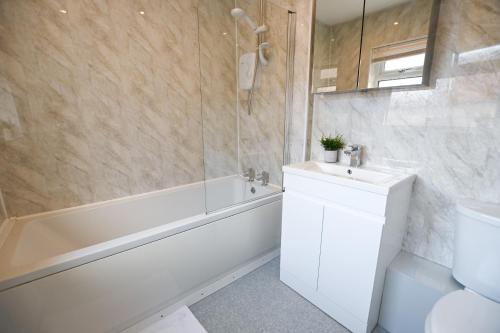 ein Badezimmer mit einer Badewanne, einem WC und einem Waschbecken in der Unterkunft Clarice House by YourStays in Etruria