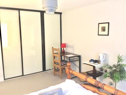 a living room with a large window with a table at Luxury Ensuite Room 2 Minutes from Cambridge Station in Cambridge