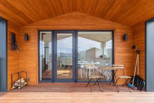 a wooden house with a glass door with a table and chairs at Mount hotel in Slavske