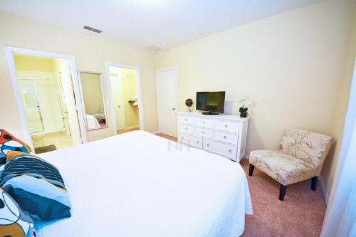 a bedroom with a white bed and a chair at Make memories with your family and friends in this beautiful home 1014 in Loughman