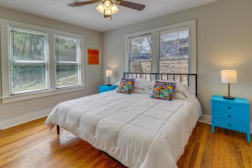 a bedroom with a bed with two night stands and two windows at Vibrant Fayetteville Home - Walk Downtown! in Fayetteville