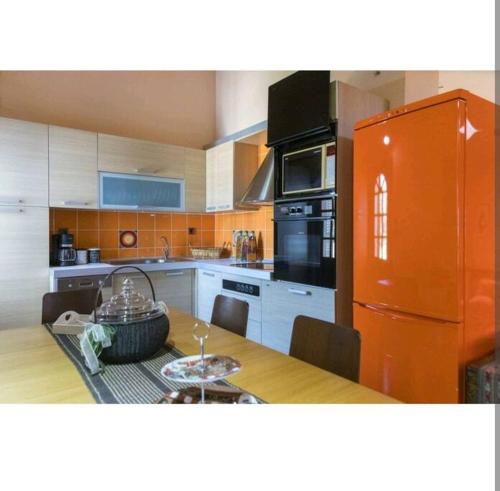 a kitchen with a table and an orange refrigerator at Casa Martina in Alexandroupoli