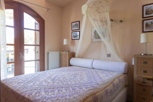a bedroom with a bed with a canopy and a window at Casa Martina in Alexandroupoli
