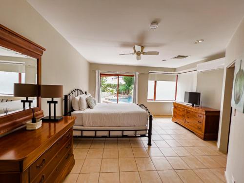 um quarto com uma cama, uma cómoda e uma televisão em Caya Bista Lama 26 em Palm-Eagle Beach