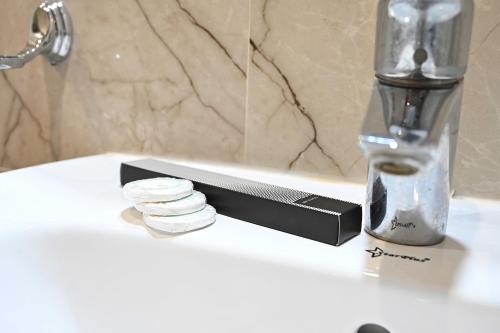 a bathroom sink with a stack of pills on it at Liwan Alkhaleej for serviced apartments ليوان الخليج للشقق المخدومة in Riyadh